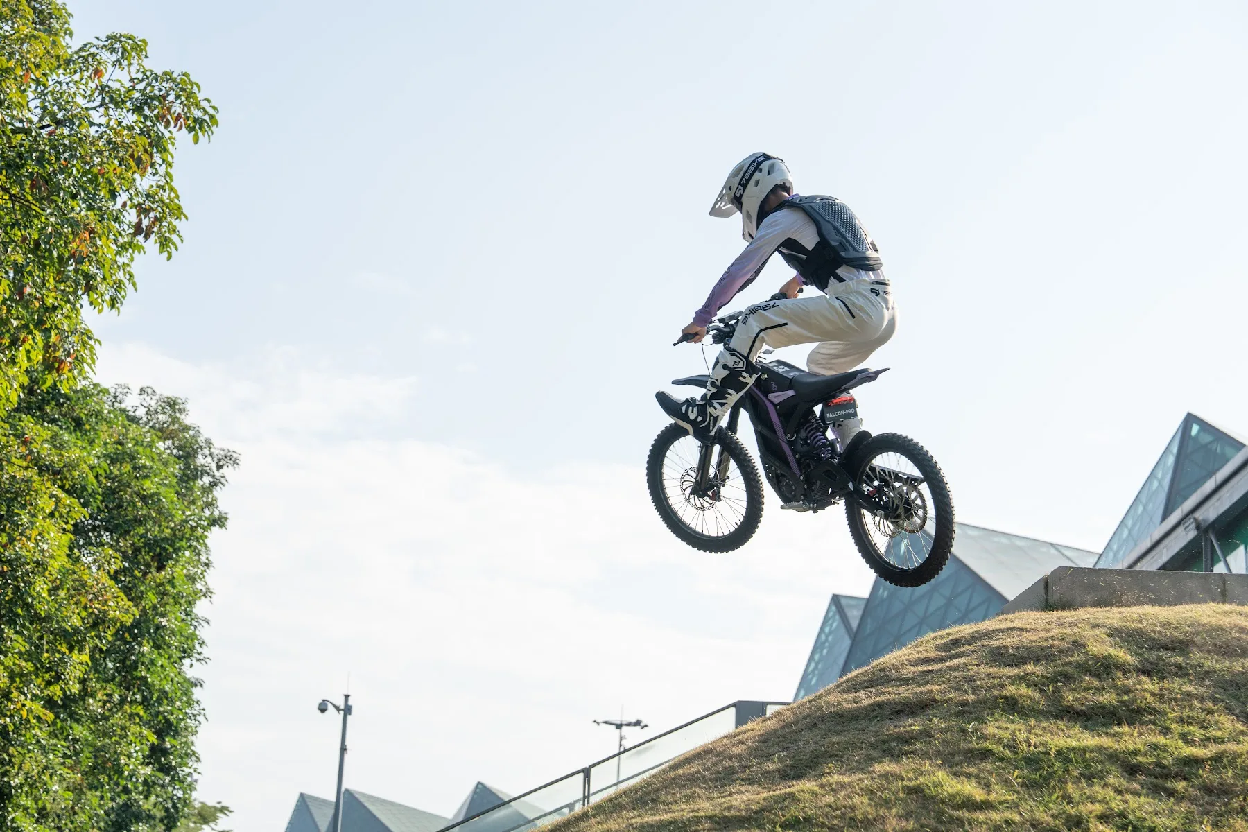 Rider jumping a 79BIKE Falcon Pro off a grass ramp